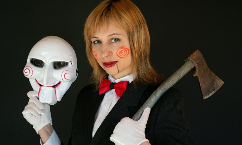 Woman in horror-themed costume holding an axe and mask, suited for Halloween.