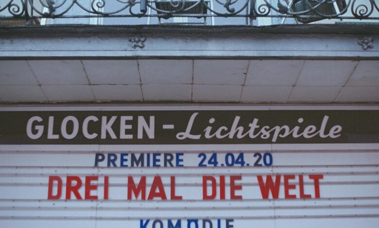 Retro cinema sign announcing 'Drei Mal Die Welt' premiere on April 24, 2020.
