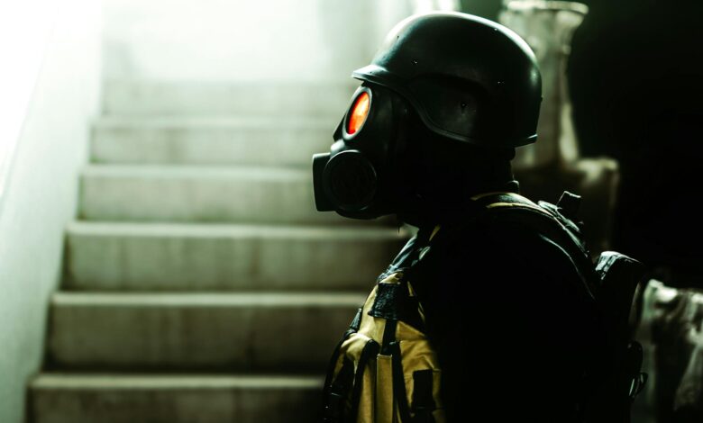 Dark indoor scene featuring a figure in gas mask and helmet, evoking horror and Halloween vibes.