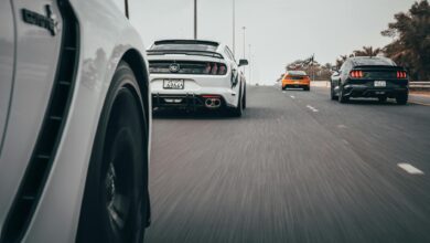 Dynamic view of sports cars racing on a highway, showcasing speed and motion.