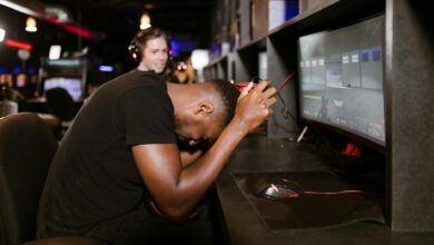 An adult male gamer shows frustration while playing a computer game in an esports arena.