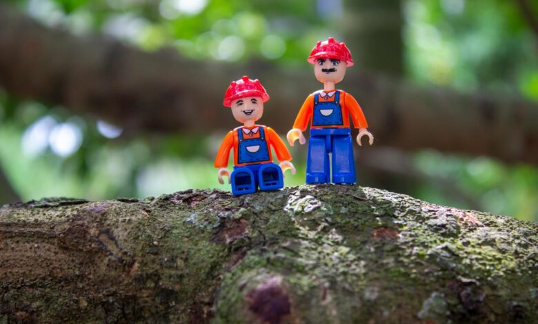 Colorful toy figures with helmets on a tree branch, showcasing creativity and playfulness.