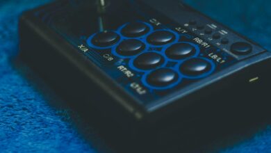 Detailed view of a game controller on a blue surface, highlighting buttons and joystick.