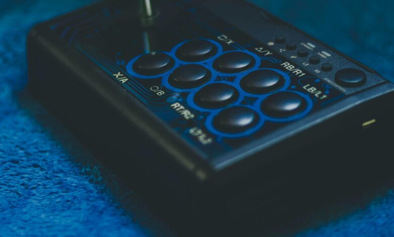 Detailed view of a game controller on a blue surface, highlighting buttons and joystick.
