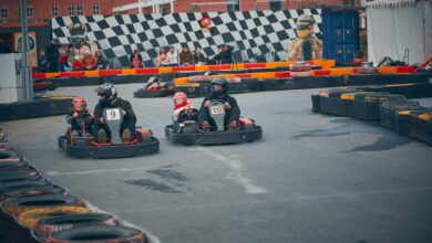 Thrilling outdoor go-kart race with competitors wearing helmets speeding on a track.
