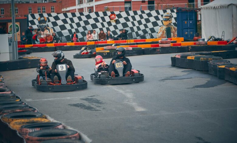 Thrilling outdoor go-kart race with competitors wearing helmets speeding on a track.