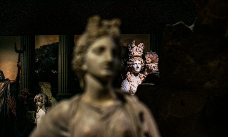 Intricate classical marble statues displayed in a dimly lit museum setting, showcasing artistic craftsmanship.