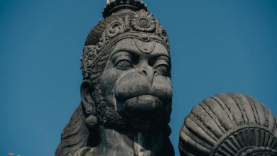 Captivating close-up of a stone Hanuman statue, a revered figure in Hinduism, under a blue sky in Bengaluru, India.