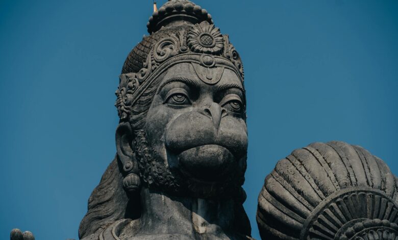 Captivating close-up of a stone Hanuman statue, a revered figure in Hinduism, under a blue sky in Bengaluru, India.