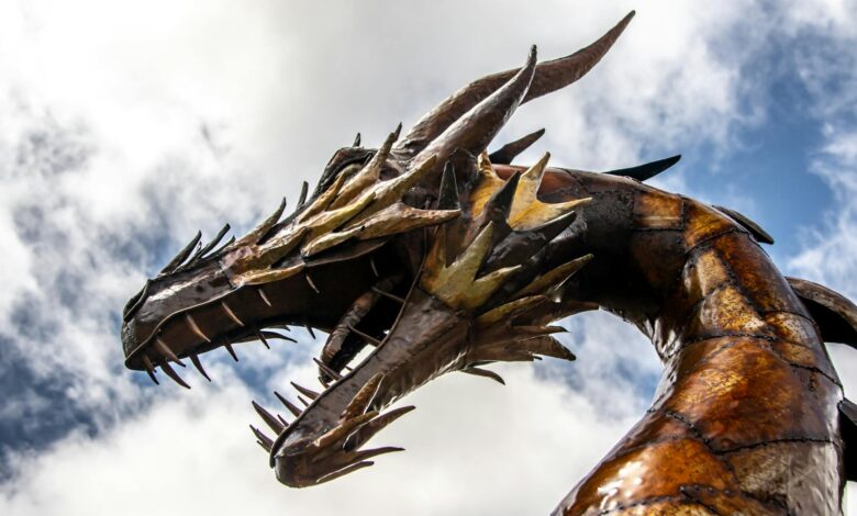 A striking low-angle view of a dragon statue set against a cloudy sky.