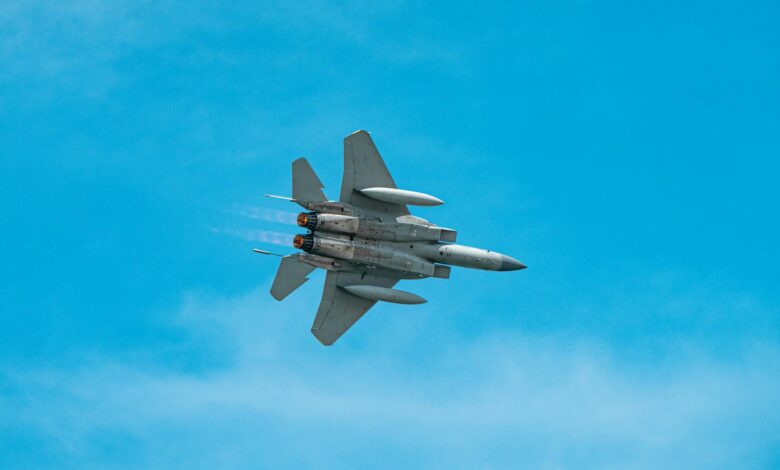 A military jet aircraft soaring through a clear blue sky, showcasing agility and power.