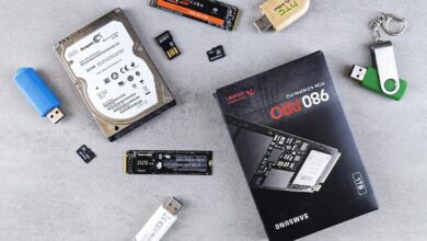 Flat lay of various computer data storage devices on a gray surface.