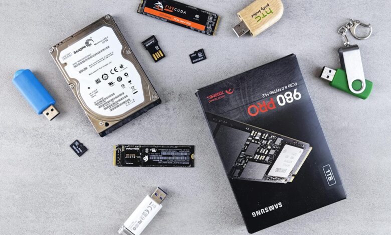 Flat lay of various computer data storage devices on a gray surface.