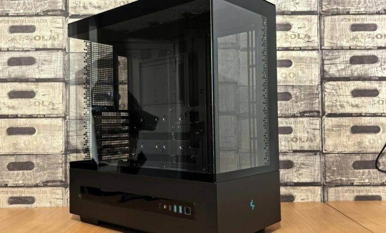 Sleek black and glass computer case with futuristic design on a wooden tabletop.