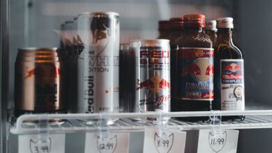 Variety of energy drinks displayed with prices on a refrigerator shelf.