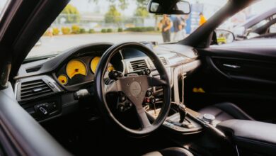 Interior of a luxury sports car with yellow dashboard gauges and custom steering wheel.