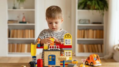 A young boy plays with colorful construction blocks at home, fostering creativity and imagination.