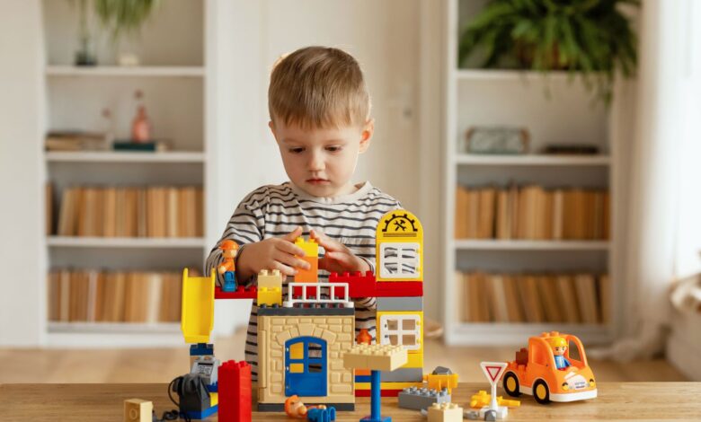 A young boy plays with colorful construction blocks at home, fostering creativity and imagination.