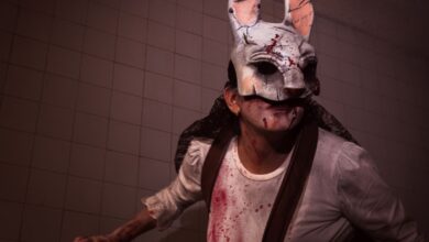 Frightening rabbit mask worn during Halloween with bloodstained costume and eerie lighting.