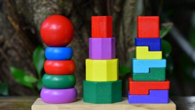 Brightly colored wooden stacking toy set on wooden base, outdoors.