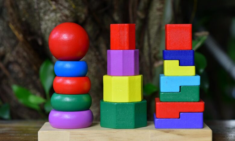 Brightly colored wooden stacking toy set on wooden base, outdoors.