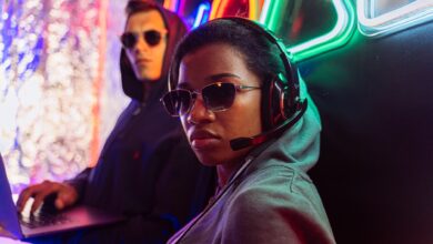 Two stylish gamers with headsets in a neon-lit room, embodying modern digital culture.