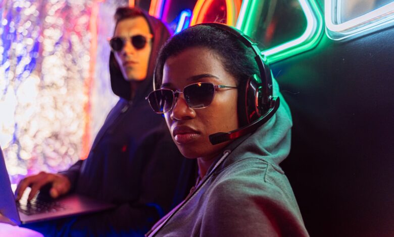 Two stylish gamers with headsets in a neon-lit room, embodying modern digital culture.