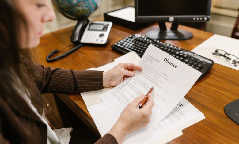 A lawyer examines divorce documents at a desk in a law office setting, emphasizing professionalism.