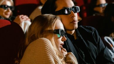 A couple immersed in a 3D movie experience at the cinema, enjoying a thrilling film.
