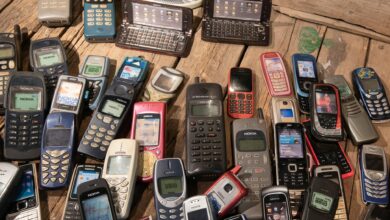 An assortment of retro mobile phones displayed on a rustic wooden surface, showcasing nostalgia.