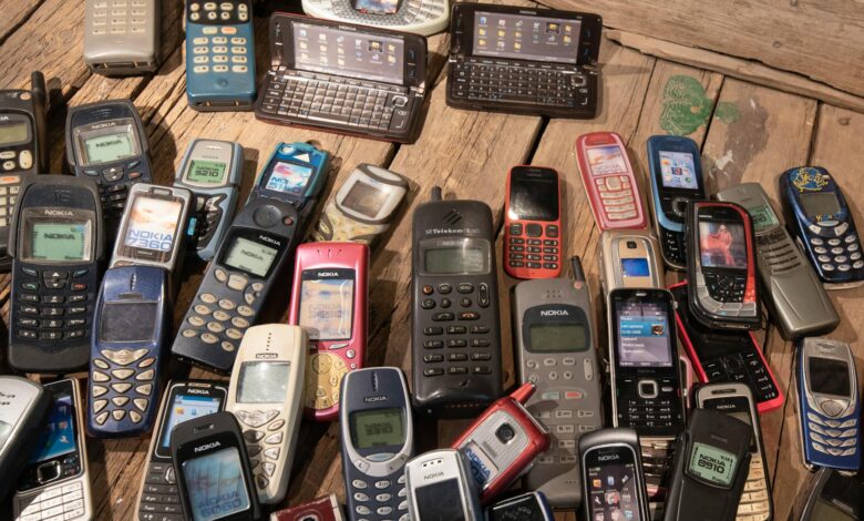 An assortment of retro mobile phones displayed on a rustic wooden surface, showcasing nostalgia.