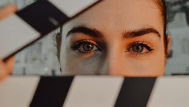 Intriguing close-up of a person's eyes behind a movie clapperboard, symbolizing filmmaking artistry.