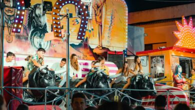 People enjoying a vibrant bull ride at an outdoor funfair at night.