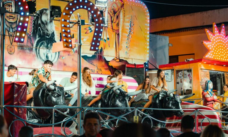 People enjoying a vibrant bull ride at an outdoor funfair at night.
