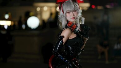 A cosplayer in a captivating futuristic costume poses outdoors during a night event.