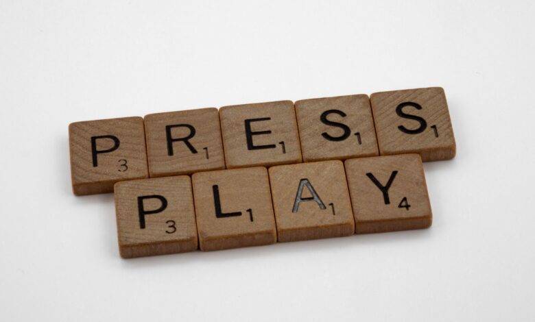 Scrabble tiles arranged to spell 'Press Play' on a white background.