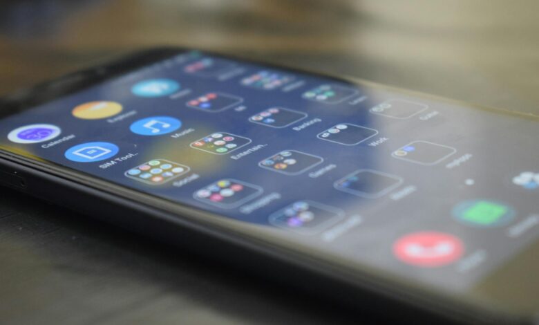 Close-up shot of a smartphone screen showing various app icons, indicating digital technology use.