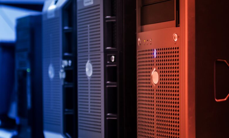 Close-up of tower servers in a data center with blue and red lighting.