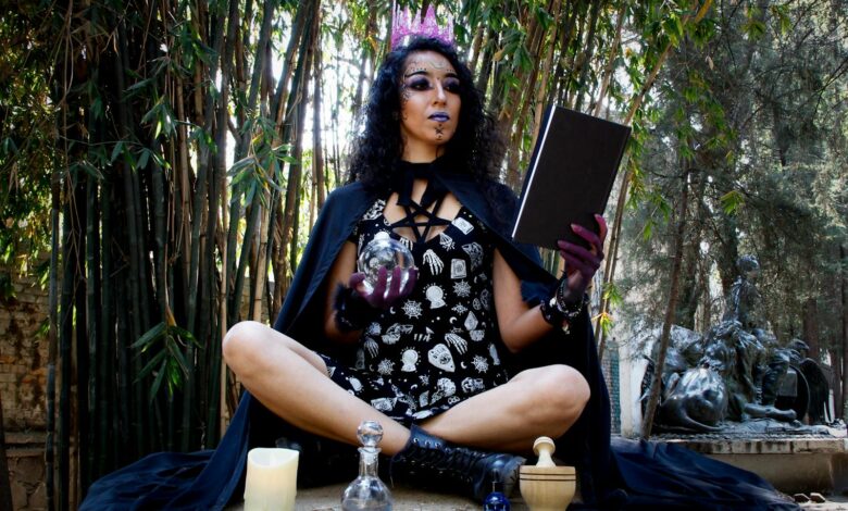 A mysterious woman conducts a witchcraft ritual with candles and potions in a forest.