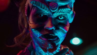 Close-up of a mysterious creature with creative prosthetic makeup under neon lights, perfect for Halloween themes.