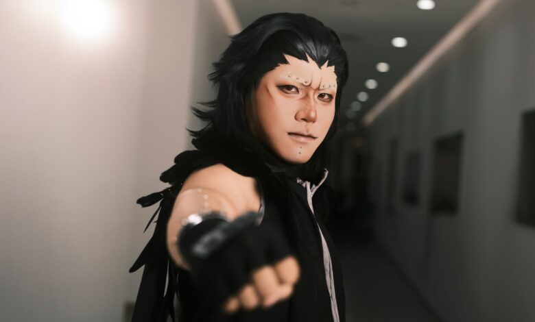 Captivating portrait of a cosplayer with intricate makeup in a dimly lit hallway.
