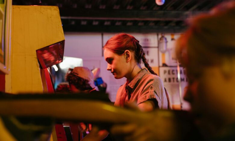 Teens playing at a vintage arcade with colorful lighting creating a nostalgic atmosphere.