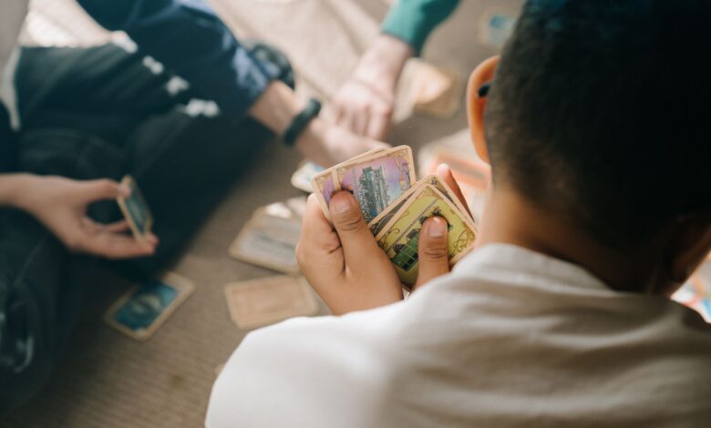 Three children engaged in a strategic card game session, focusing intently on their hands.