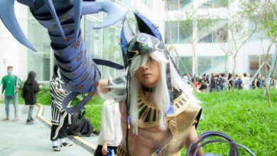 Young adult in cosplay costume at outdoor event with futuristic armor.