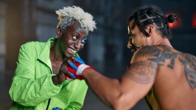 Two men engage in a friendly martial arts practice in an urban setting, showcasing vibrant personalities.