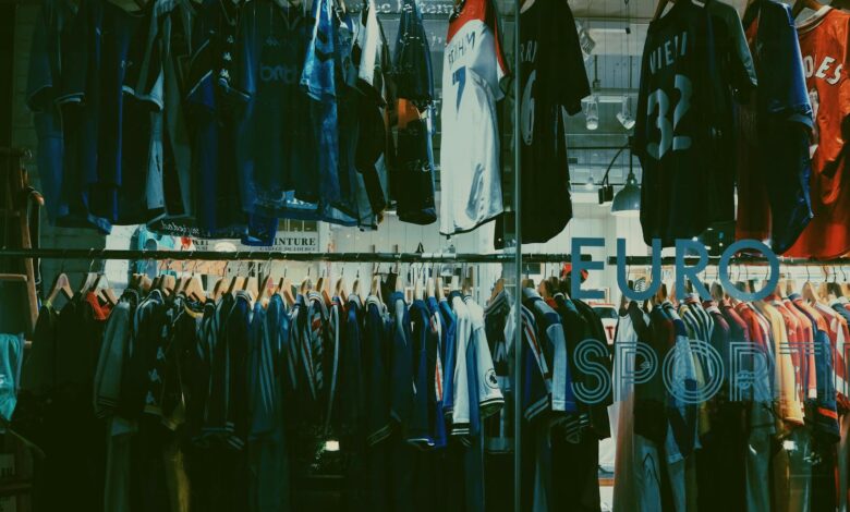 A variety of football jerseys on display in a Tokyo clothing store, highlighting a vibrant shopping scene.
