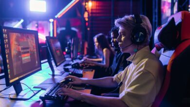 Gamers engaged in a competitive session, equipped with headsets and monitors in an immersive setup.