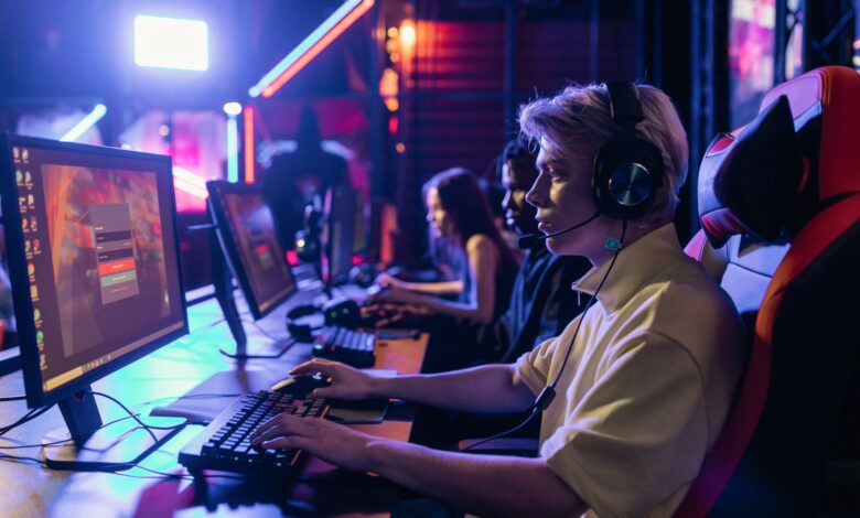 Gamers engaged in a competitive session, equipped with headsets and monitors in an immersive setup.