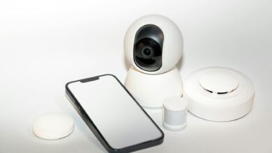 Collection of smart home security gadgets with a smartphone display.