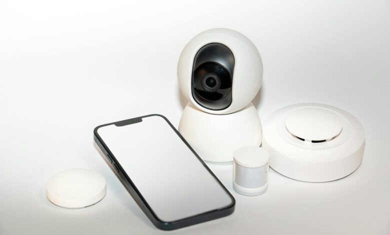 Collection of smart home security gadgets with a smartphone display.